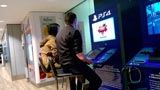 PS4: uomo connette la propria console al monitor dell'aeroporto e gioca online. Guardate